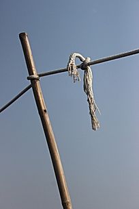蓝天下竹竿晾衣杆上的白绳结