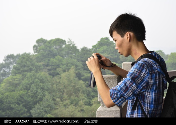 侧拍拿着数码相机的摄影师