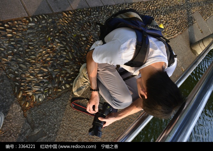 蹲在湖边摄影的摄影师