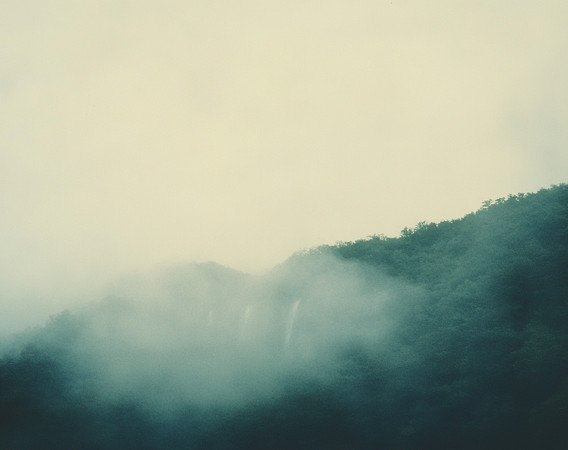 薄雾缭绕的山峦中瀑布如丝带般垂落 薄雾缭绕的山峦中瀑布如丝带般垂落