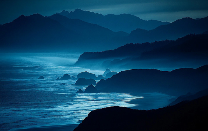 山峦映衬下的海景晨雾轻绕宁静的海岸线