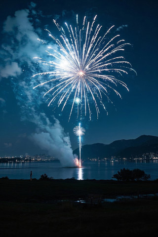 烟花在水面上方的天空中有人站在海滩上