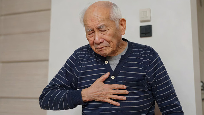 老人在家中捂着胸口