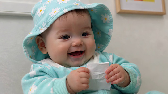 戴花帽婴儿手持纸巾画面