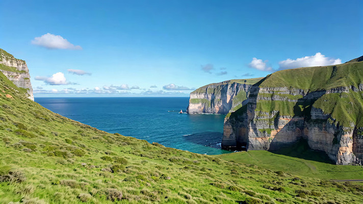 海边绿色山崖与蓝色海洋景观