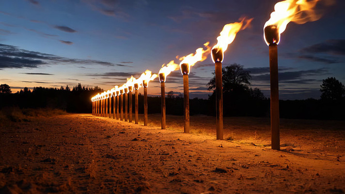 户外黄昏点燃的一排火把 户外黄昏点燃的一排火把