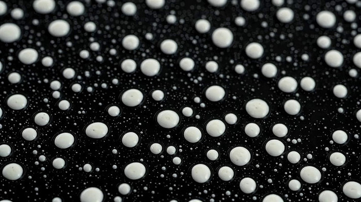 黑色背景上的白色液滴特写