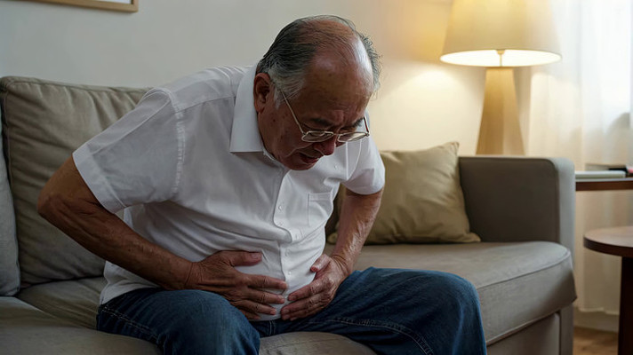 老人在家中捂着肚子显痛苦