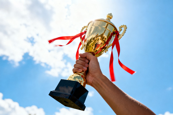 蓝天白云下金色奖杯与红丝带 蓝天白云下金色奖杯与红丝带