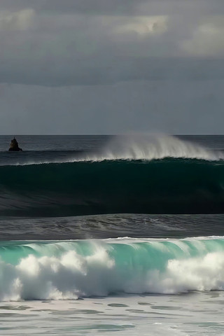 海洋中汹涌海浪与远处船只