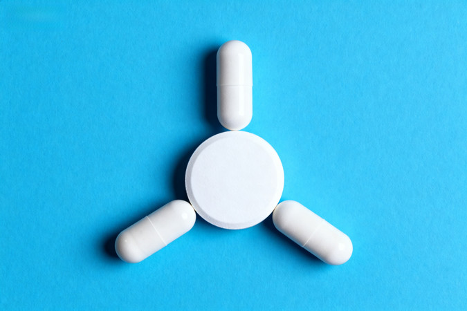 白色药片和胶囊在蓝色背景下的排列 白色药片和胶囊在蓝色背景下的排列