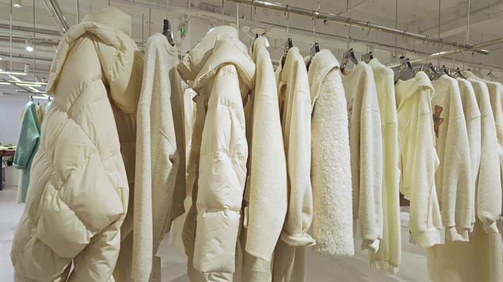 服装店冬季女装外套白色羽绒服挂衣架展示 服装店冬季女装外套白色羽绒服挂衣架展示