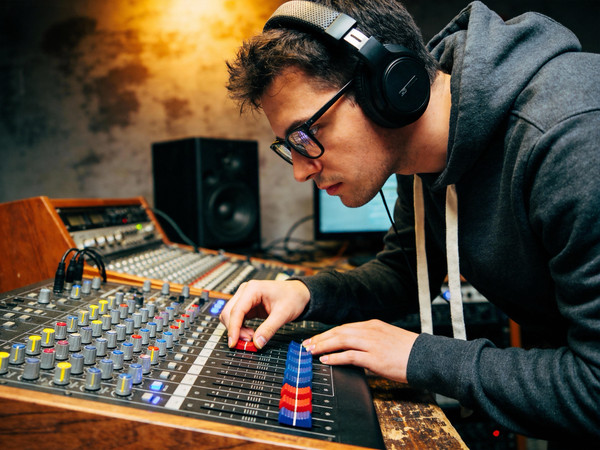 录音棚里调试设备的混音师 录音棚里调试设备的混音师