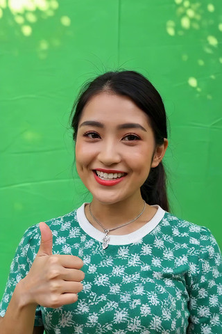 绿幕前竖大拇指微笑的女性 绿幕前竖大拇指微笑的女性