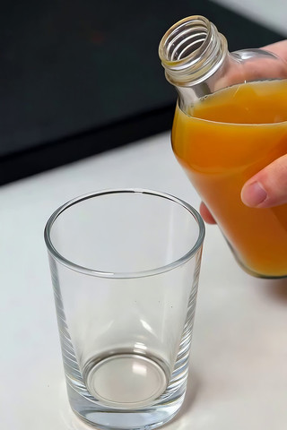 手往玻璃杯倒橙汁画面 手往玻璃杯倒橙汁画面