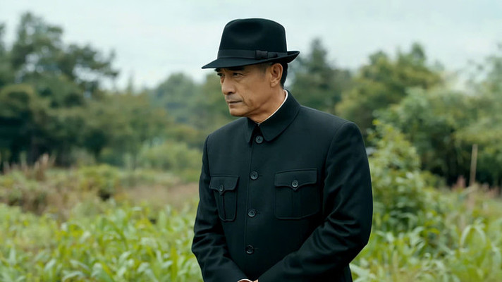 戴礼帽男子站立于绿植背景前 戴礼帽男子站立于绿植背景前