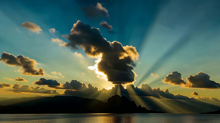 海上日出阳光穿透云层景象 海上日出阳光穿透云层景象