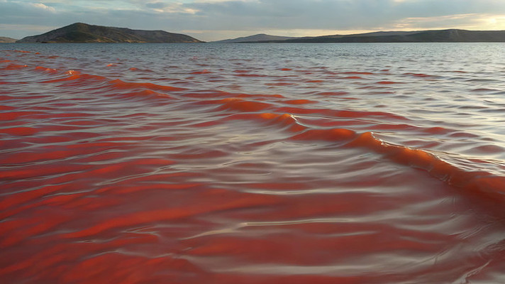 红色湖水与远处山峦景观 红色湖水与远处山峦景观