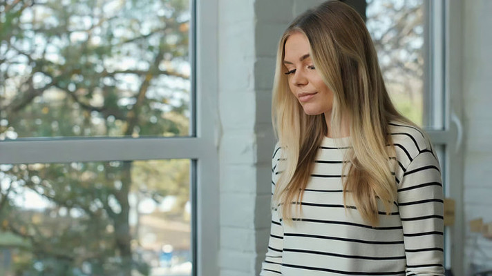 金发女子窗边站立特写 金发女子窗边站立特写