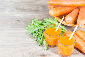 胡萝卜汁木桌上两杯胡萝卜汁和切开的萝卜俯拍两杯胡萝卜汁两杯波萝卜