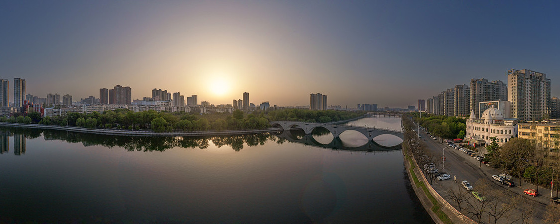宽幅静谧河畔的城市晨曦全景